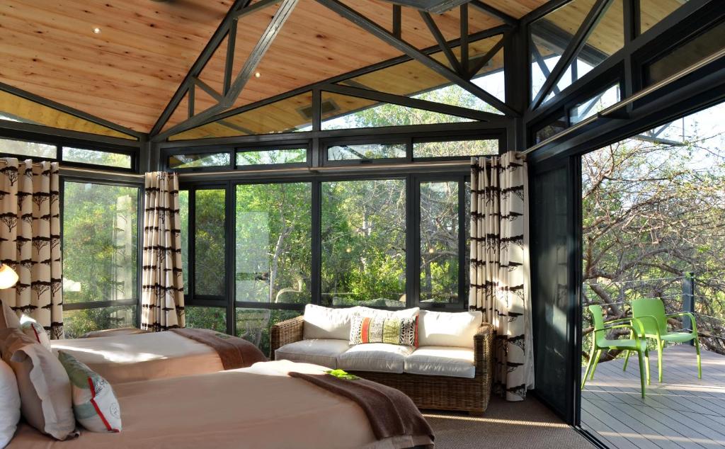 a bedroom with two beds in a room with windows at Greenfire Game Lodge in Balule Game Reserve