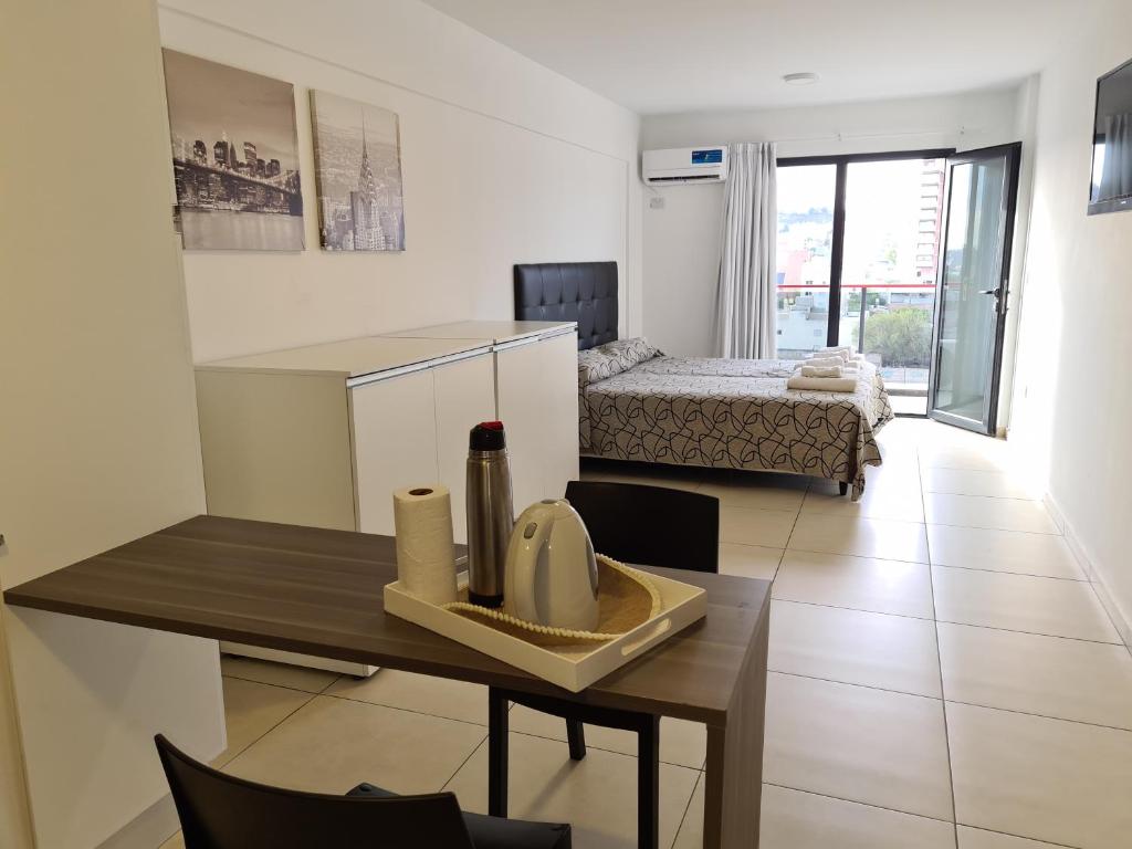 a living room with a table and a bedroom at SMA FLATS in Neuquén