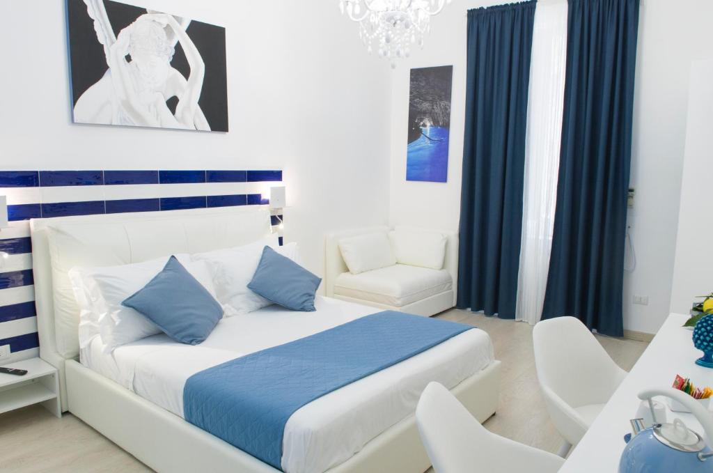 1 dormitorio con cama, escritorio y silla en Maison San Paolo, en Sorrento