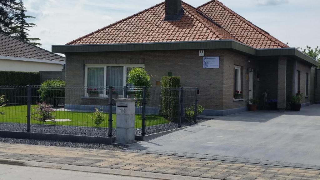 une maison avec une clôture devant elle dans l'établissement B&B Sogni d'oro, à Lovendegem