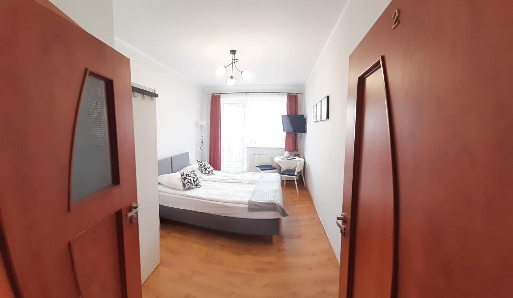 a bedroom with a bed and a room with a window at Pokoje Gościnne Justynka in Władysławowo