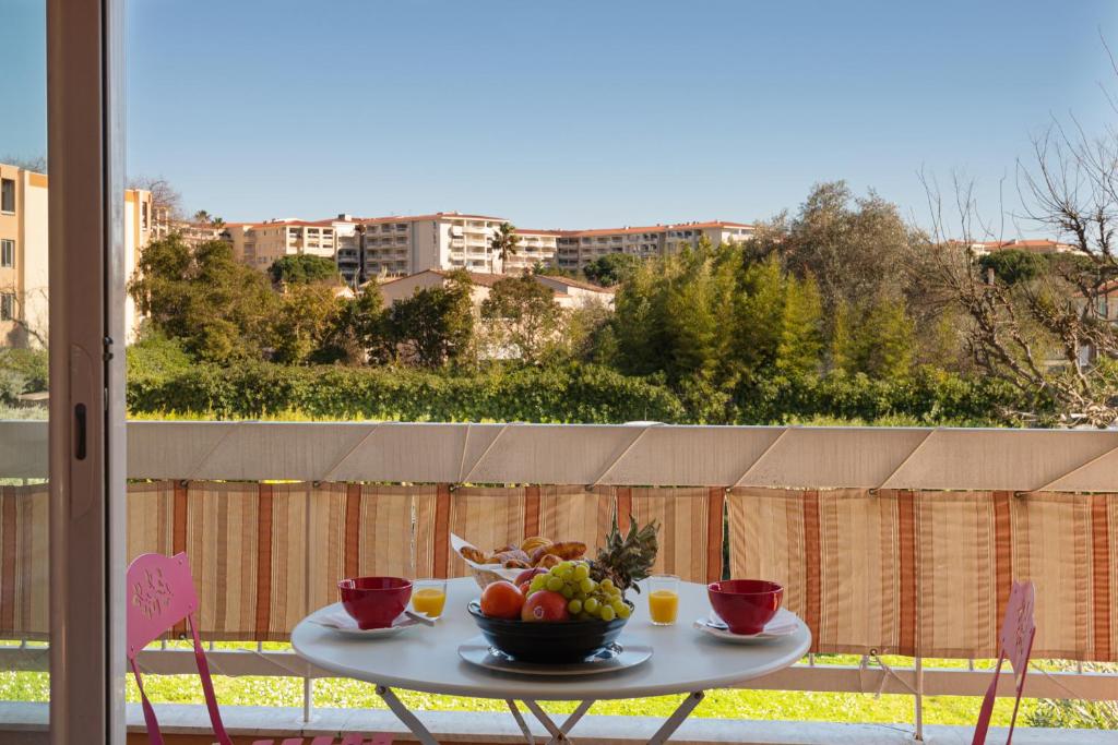 un tavolo con un cesto di frutta sul balcone di Les Jasmins Apartment a Vallauris