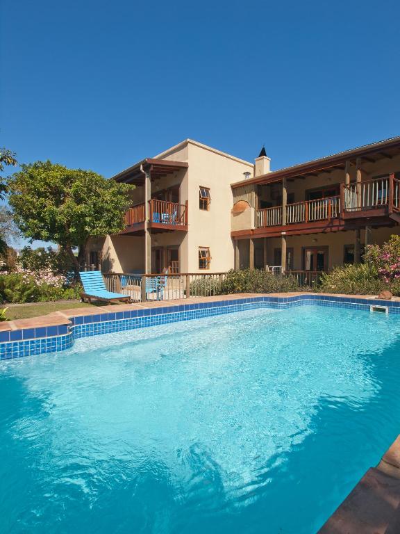 una grande piscina di fronte a una casa di At the Woods Guest House a Stormsrivier