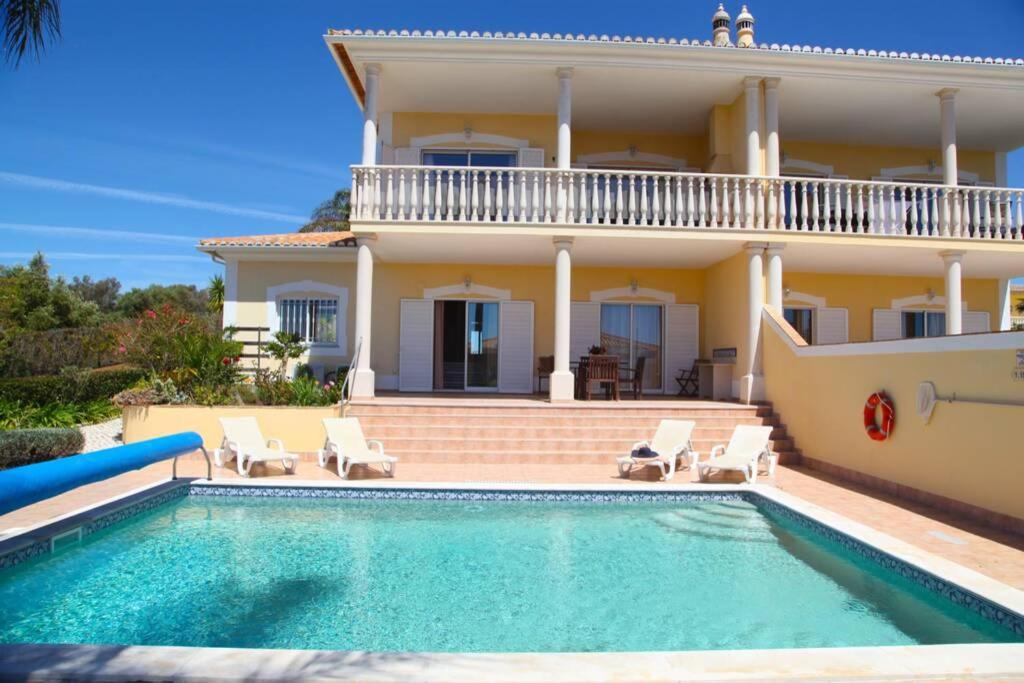 een villa met een zwembad voor een huis bij Vila G, Mira Luz in Luz