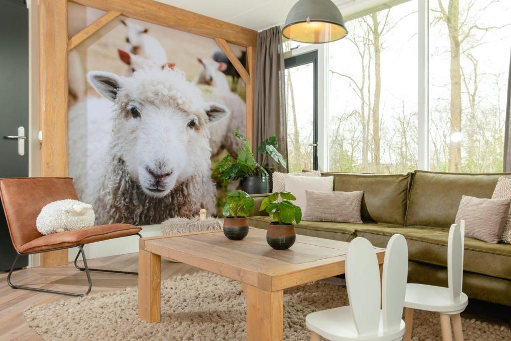 a living room with a sheep picture of a couch at 8- person childbungalow - Theme Farm Adapted in Zuna