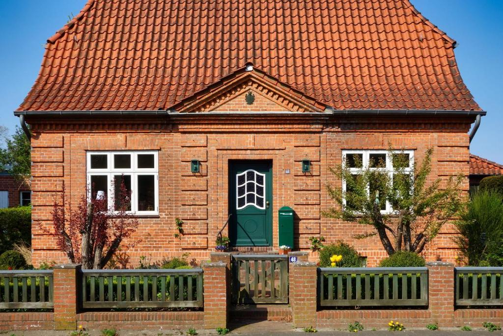 una casa de ladrillo rojo con una puerta verde en Stadthaus Rothensande, en Schleswig