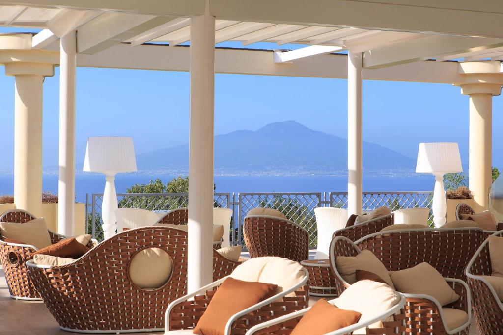 a porch with chairs and a view of the ocean at Atlantic Palace Hotel in Sorrento