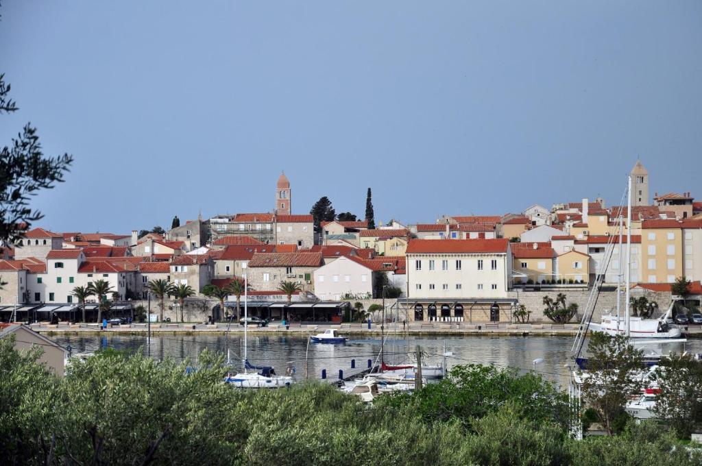 una ciudad con barcos en el agua y edificios en Rose rooms at island of Rab en Rab