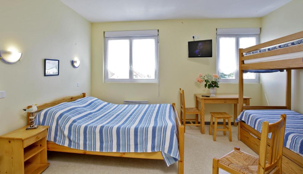 - une chambre avec 2 lits, une table et un bureau dans l'établissement Hôtel de l'Océan, à Notre-Dame-de-Monts