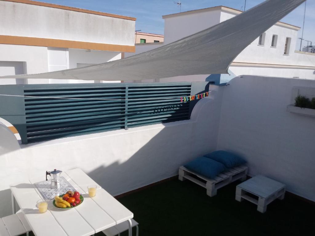 Un balcón con una mesa y un bol de fruta en Apartamento Rotasol, en Rota