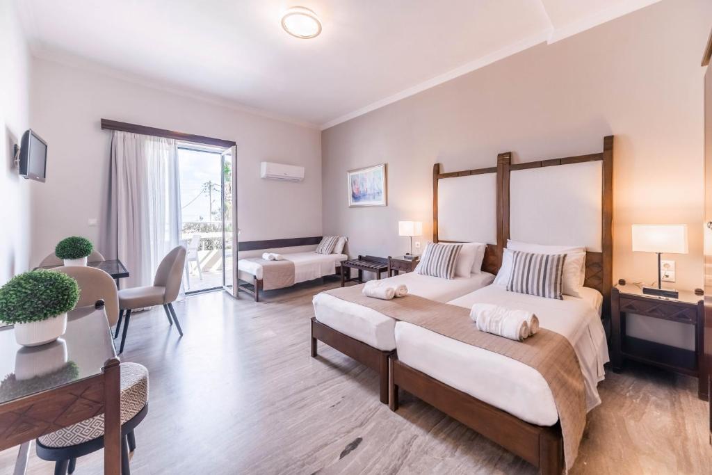 a bedroom with two beds and a living room at Kalamaki Mare Suites in Kalamaki
