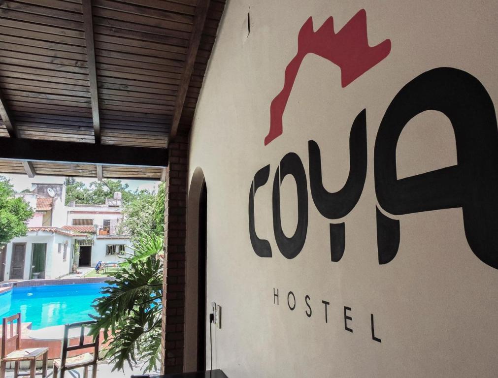 a sign for a hotel next to a swimming pool at COYA HOSTEL in Salta