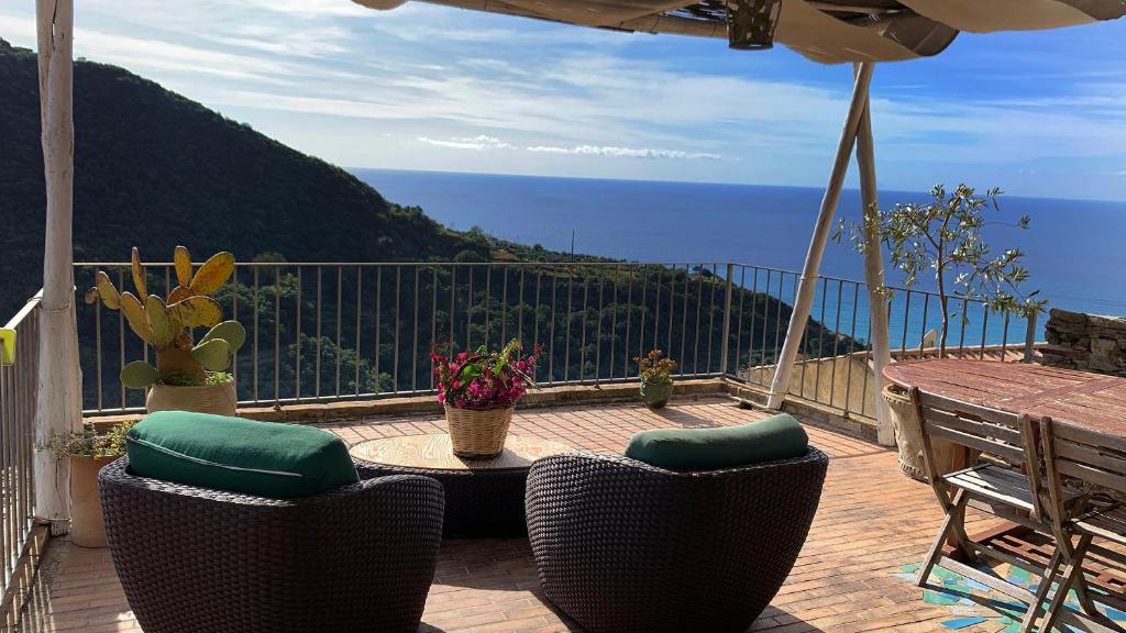 d'un balcon avec une table et des chaises donnant sur l'océan. dans l'établissement Albergo diffuso Ecobelmonte, à Belmonte Calabro