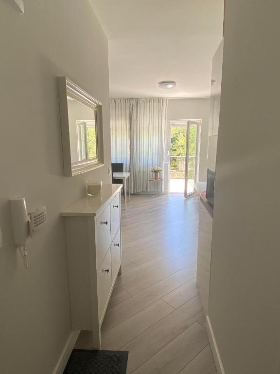 biała łazienka z umywalką i lustrem w obiekcie Aida Apartman Siófok w Siófoku