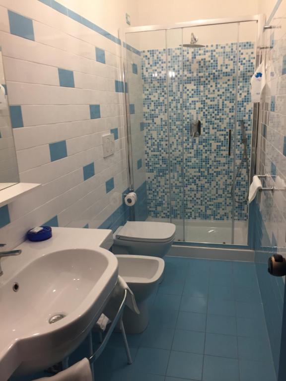 a bathroom with two toilets and a sink and a shower at Elba Hotel in Rosignano Solvay