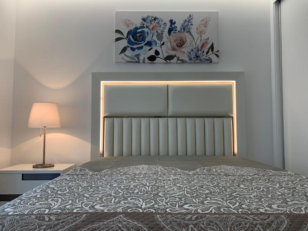 een slaapkamer met een bed met een lamp en een schilderij bij Apartamentos Quebra-Mar 2 in Nazaré