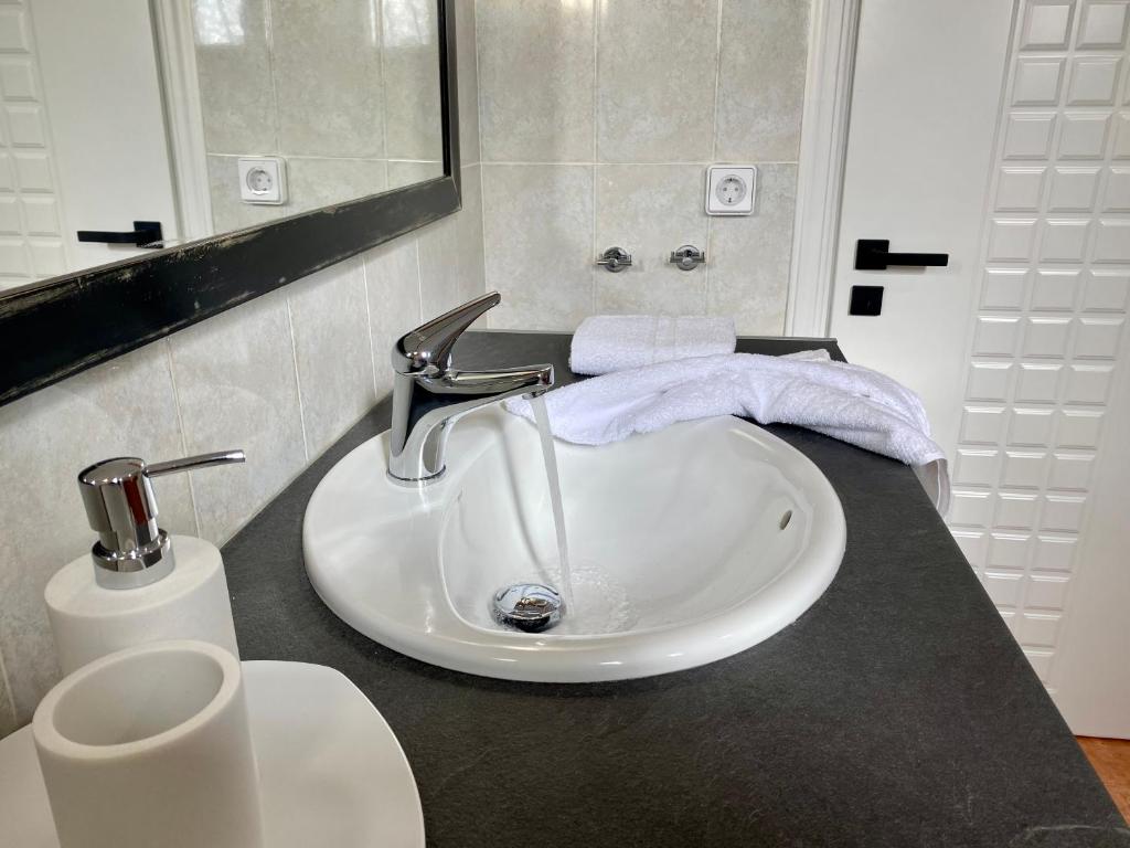 a white sink in a bathroom with a mirror at PORTA HOME modern and hospitable in Naxos Chora