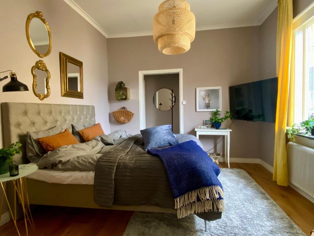 a bedroom with a bed with blue and orange pillows at lägenhet på innergården in Alingsås