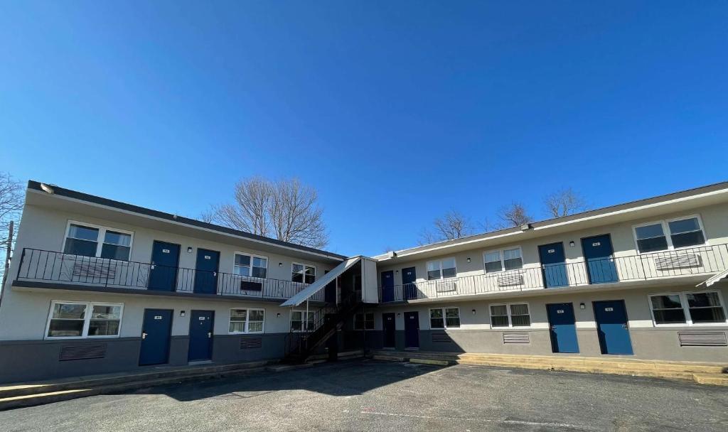 un edificio de apartamentos con puertas azules y aparcamiento en Tinton Falls NJ Neptune en Tinton Falls