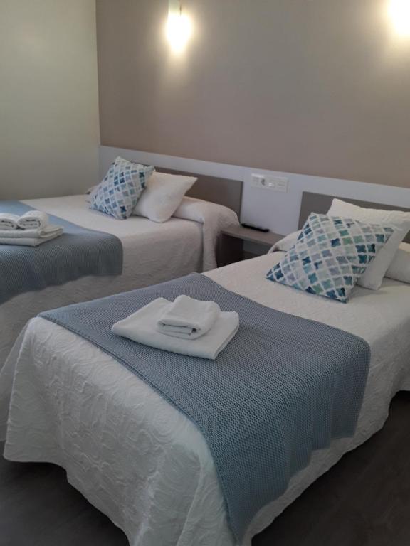 a hotel room with two beds with towels on them at Pension Principado in Cangas de Onís