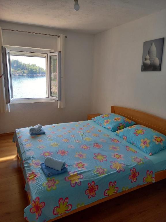 sypialnia z łóżkiem z niebieską kołdrą i oknem w obiekcie House Slavka w mieście Gdinj