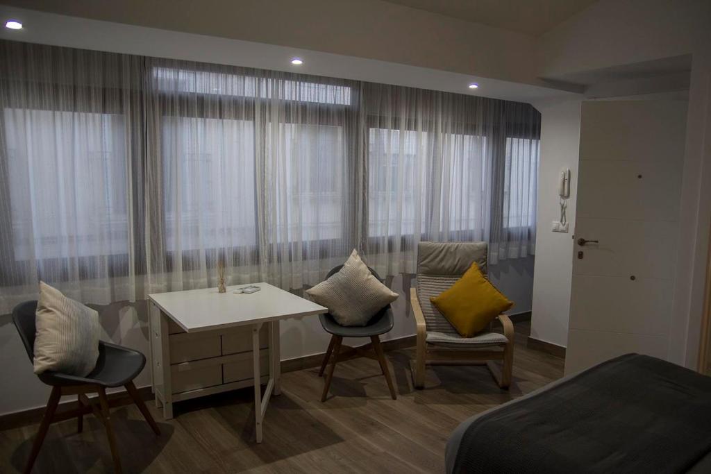 Habitación con cama, mesa y sillas. en Tándem House, en Priego de Córdoba