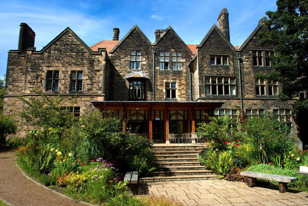 un antiguo edificio de ladrillo con una escalera delante de él en Jesmond Dene House en Newcastle