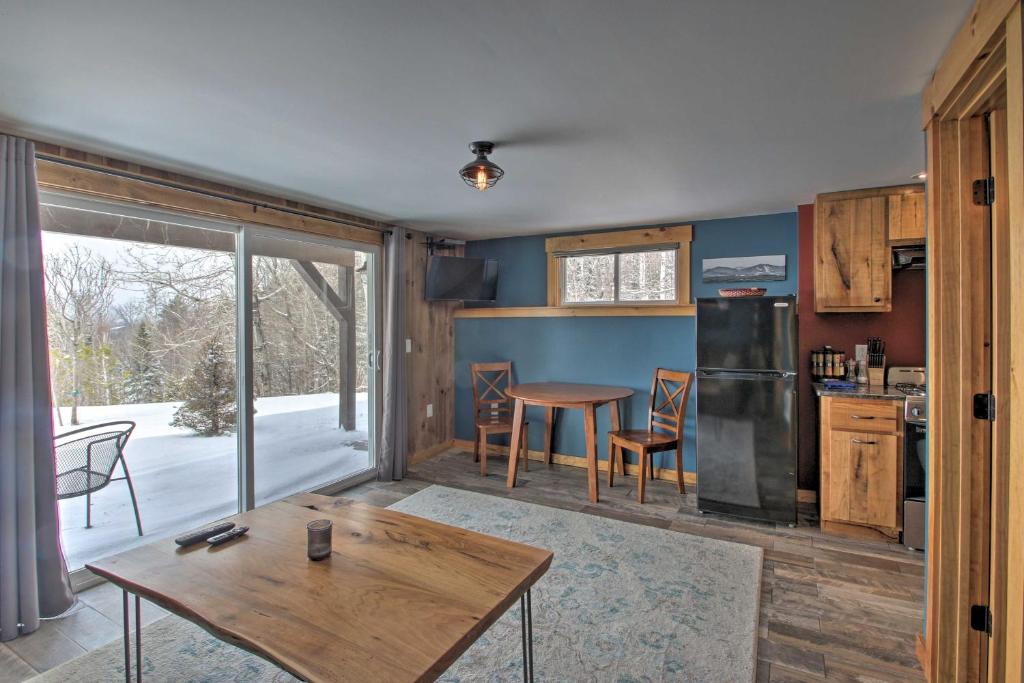 uma cozinha e sala de jantar com uma mesa e uma mesa em Cozy Condo Ski-In and Out with Burke Mountain Access! em East Burke