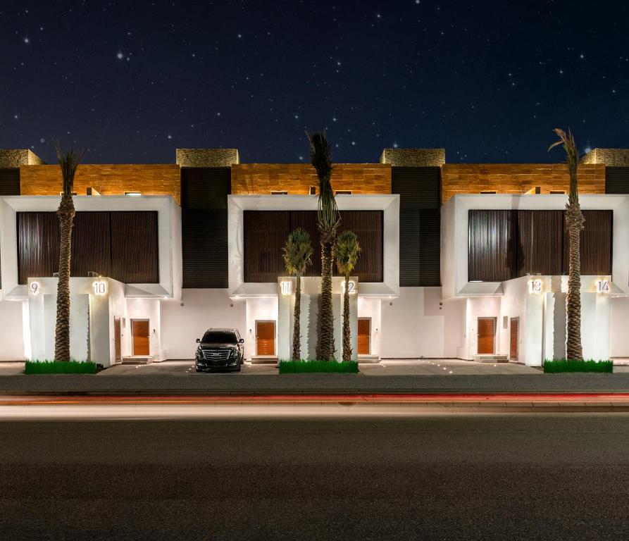 a car parked in front of a building with palm trees at Beach Time Villas Hotel in Jeddah