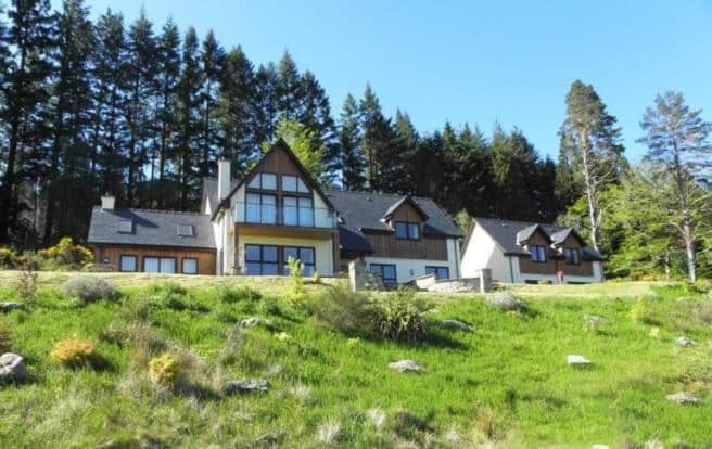 a large house on a hill in a field at An Outdoor Enthusiasts Piece of Heaven in Gairlochy