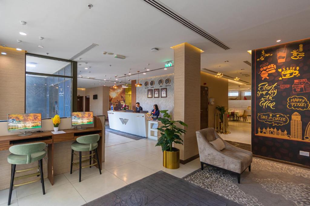 a lobby with a bar and chairs in a store at Le Wana Hotel in Dubai