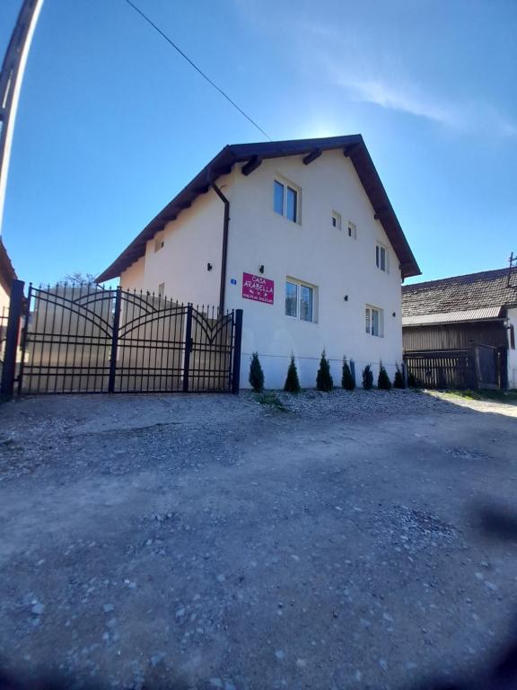 un edificio blanco con una valla delante en Casa Arabela, en Vişeu de Sus