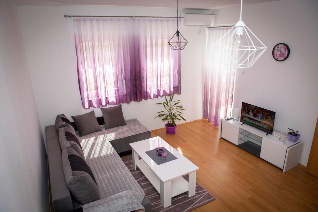 ein Wohnzimmer mit einem Sofa und einem Tisch in der Unterkunft Apartment Helena in Trebinje