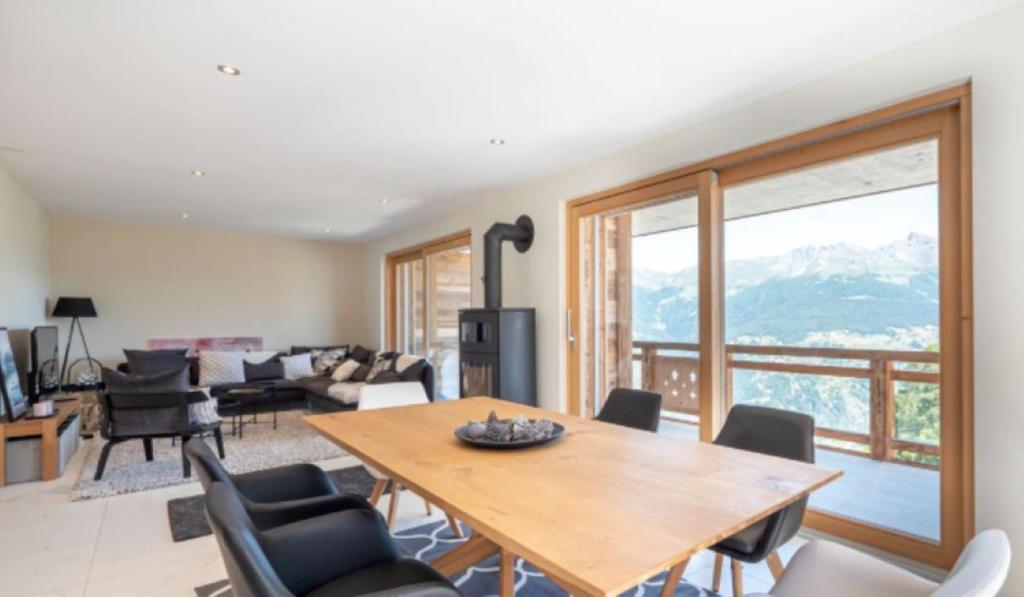 a living room with a wooden table and chairs at Magnifique appartement dans Résidence de Luxe - Dixence Resort Complexe SPA in Hérémence