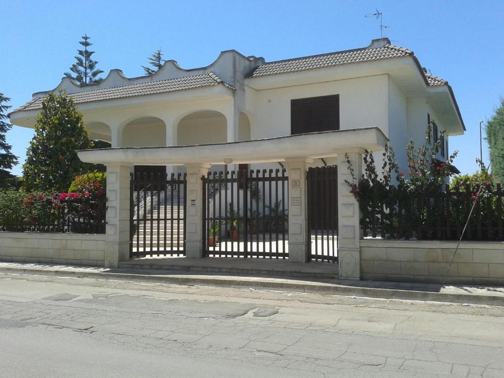 a white house with a gate in front of it at Villa Gloria Bed & Breakfast in Veglie