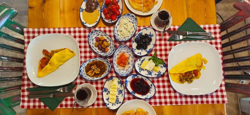 a table with plates of food on a red and white table cloth at Swiss Eviniz Hotel in Adrasan