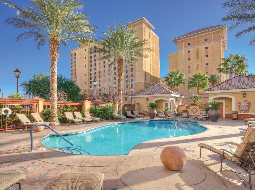 una piscina con palmeras y edificios en Club Wyndham Grand Desert, en Las Vegas