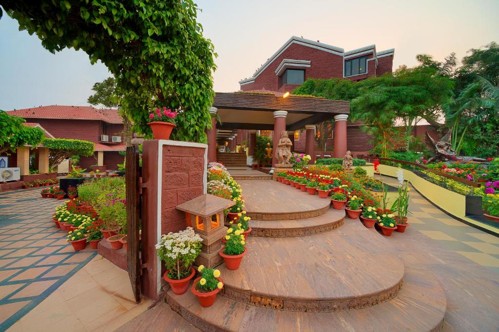 a garden with flowers in pots on a walkway at Mayfair Heritage in Puri