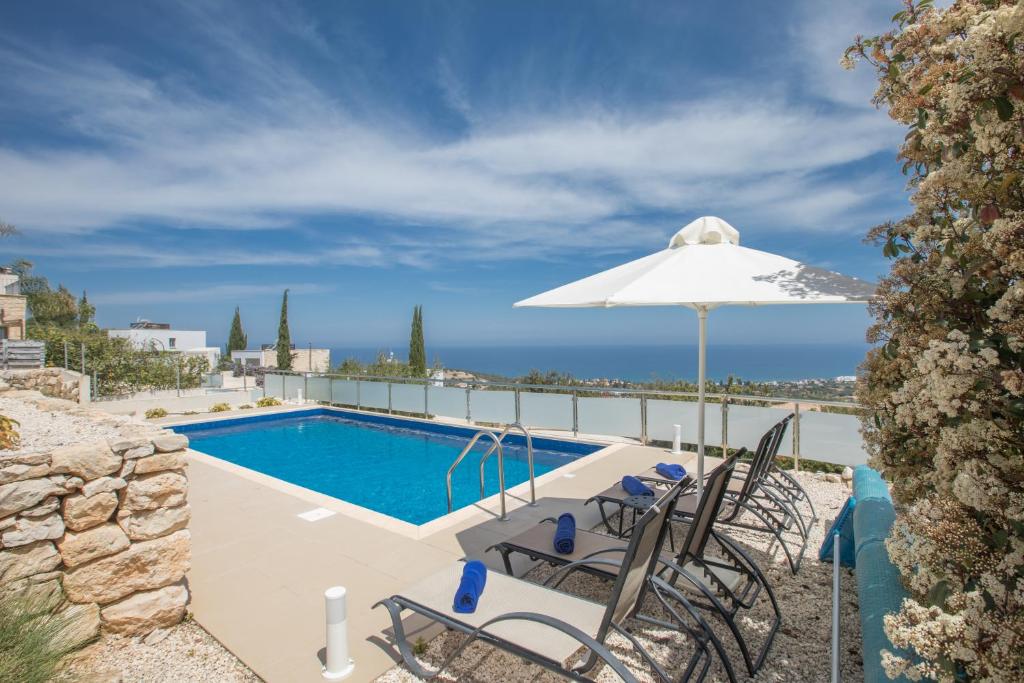 eine Villa mit einem Pool und einem Sonnenschirm in der Unterkunft Esprit Villa 30 in Polis Chrysochous