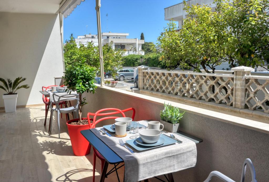 un tavolo e sedie su un balcone con vista su una strada di Vele d'Otranto B&B a Otranto