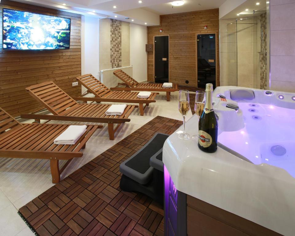 a room with a hot tub with glasses of wine at Chicago Vendégház in Szentes
