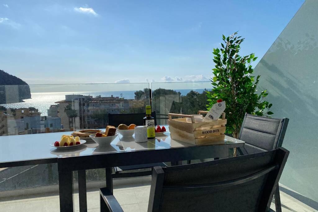 stół z talerzem jedzenia i butelką wina w obiekcie Sea view apartment 6E with pool in Cañamel beach w mieście Capdepera
