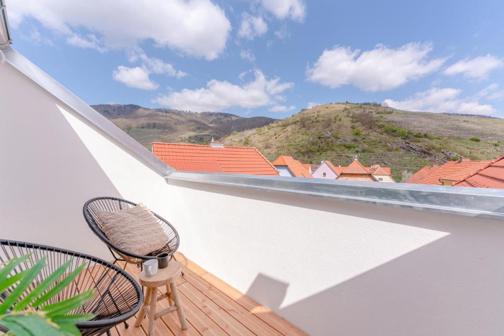 un balcone con una sedia e vista sulla montagna di Dach.Loft Spitz in der Wachau a Spitz