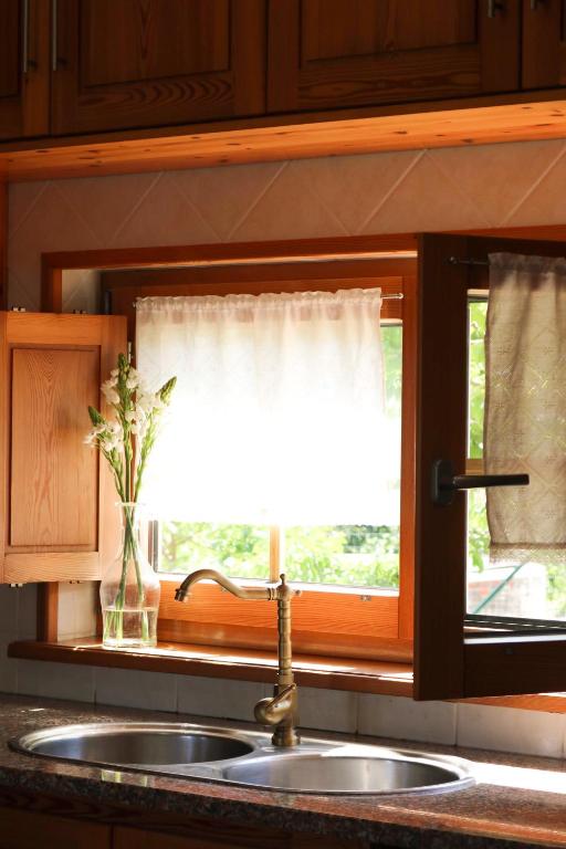 a kitchen sink and a window with a windowtaining at Quinta Amarela - B&B in Nazaré