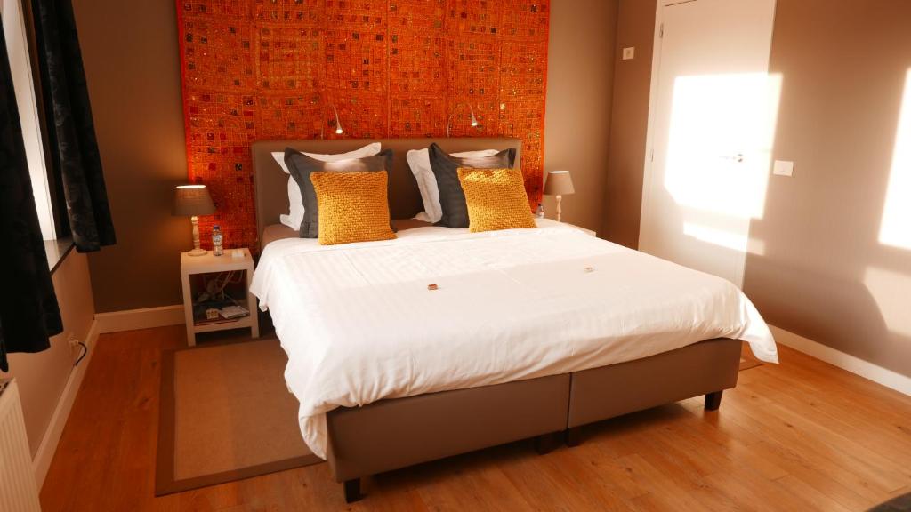 een slaapkamer met een groot bed met gele kussens bij B&B Bella en Basiel in Brugge