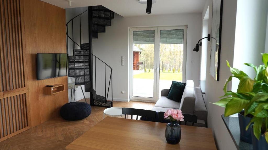 sala de estar con mesa y sofá en Apartament Osiedle Zielone, en Chmielno