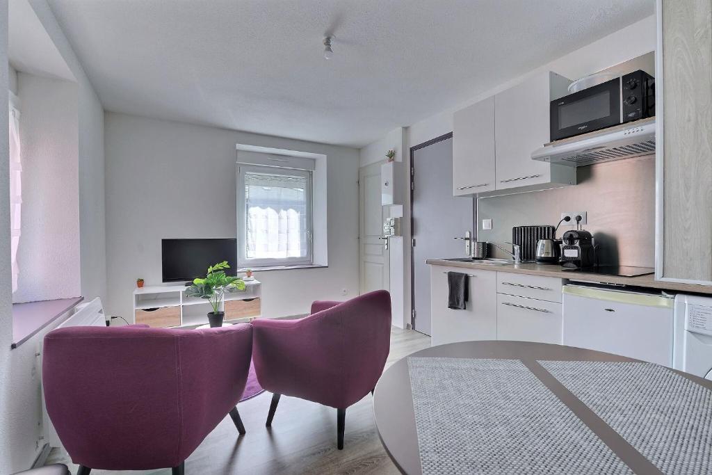 cocina con sillas moradas y mesa en una habitación en Appartement 2 pièces pleins de charmes (Géorgie) en Audincourt