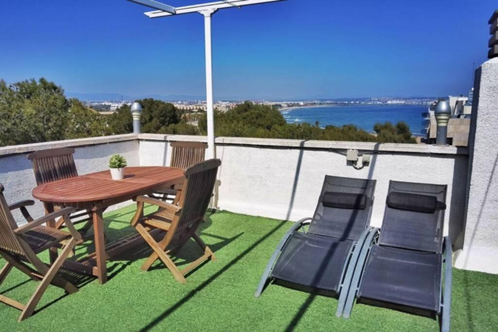 um pátio com uma mesa e cadeiras numa varanda em Barbacoa + vistas al mar + playa + piscina. em Salou