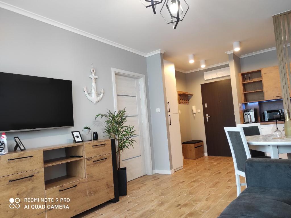 a living room with a flat screen tv on the wall at Apartament Baltic13 in Gąski