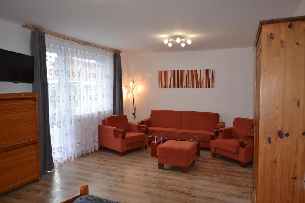 a waiting room with couches and chairs and a tv at Dom Gościnny Alba in Międzywodzie
